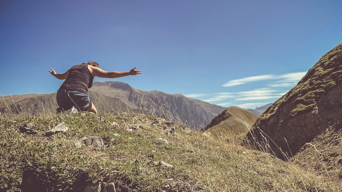 a man standing on top of a lush green hillside